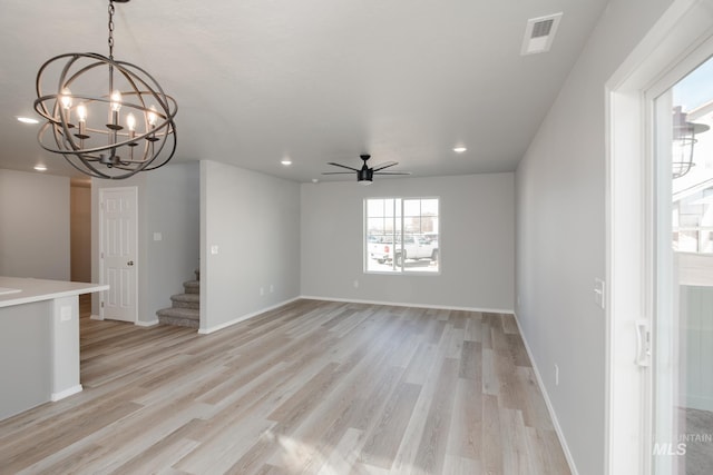 unfurnished living room featuring ceiling fan with notable chandelier and light wood-type flooring