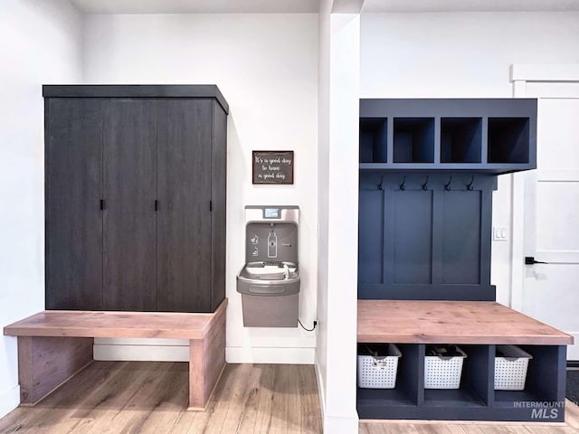mudroom with wood finished floors and baseboards