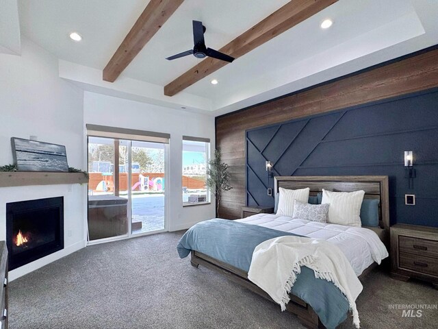 bedroom featuring access to outside, carpet flooring, a warm lit fireplace, recessed lighting, and beamed ceiling