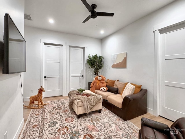living room featuring ceiling fan, light wood finished floors, recessed lighting, and baseboards