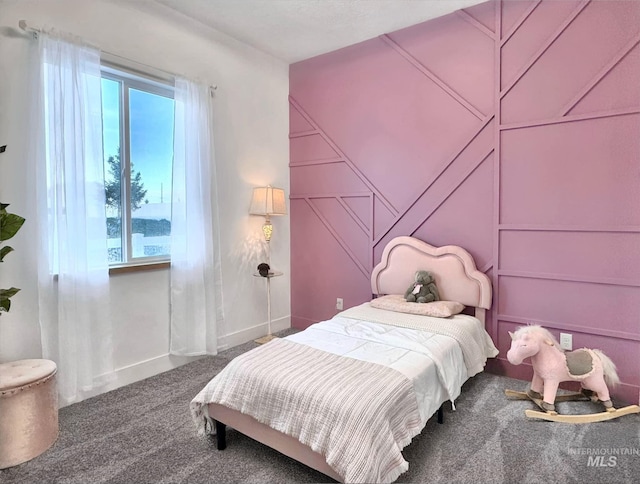 bedroom featuring carpet and a decorative wall