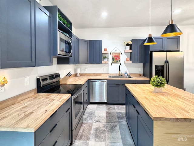 kitchen featuring open shelves, appliances with stainless steel finishes, a sink, butcher block counters, and blue cabinets