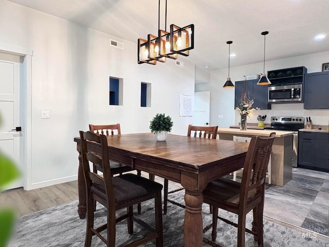 dining area with a chandelier, recessed lighting, light wood-style flooring, and baseboards