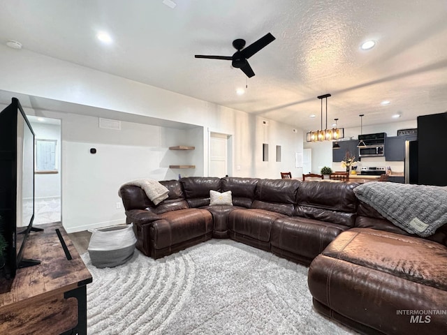 living room with a ceiling fan, recessed lighting, and a chandelier