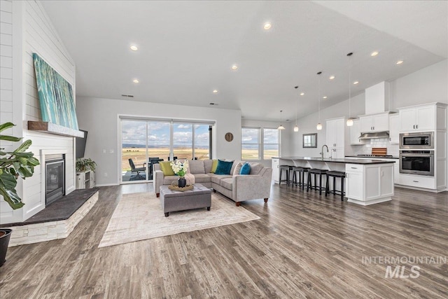 9805 Salmon Ridge Pl, Nampa, ID 83686 - living room featuring a fireplace, dark wood-style flooring, recessed lighting, and high vaulted ceiling