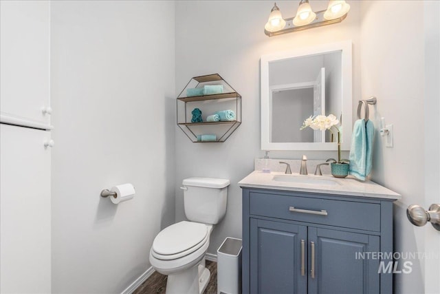 9805 Salmon Ridge Pl, Nampa, ID 83686 - half bathroom with toilet, vanity, wood finished floors, and baseboards