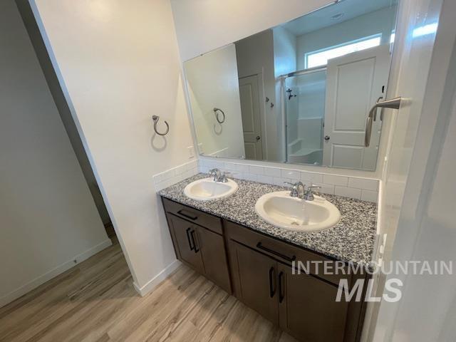 bathroom with vanity, an enclosed shower, and wood-type flooring