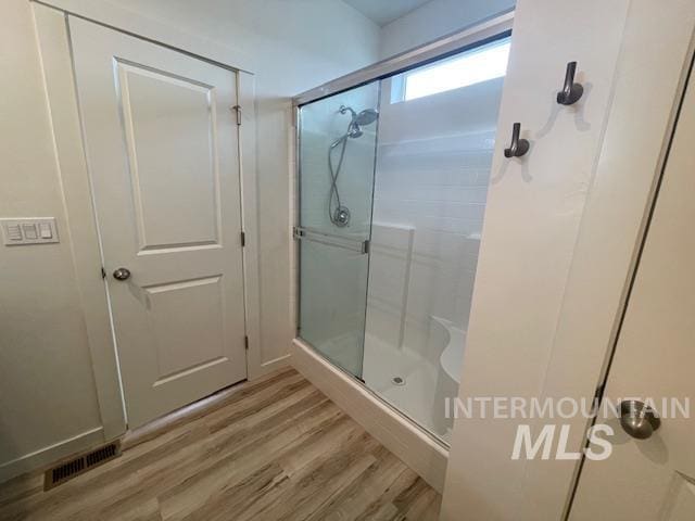 bathroom with walk in shower and hardwood / wood-style flooring