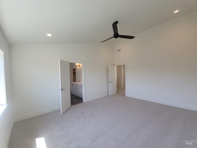 unfurnished bedroom featuring recessed lighting, vaulted ceiling, light colored carpet, and baseboards