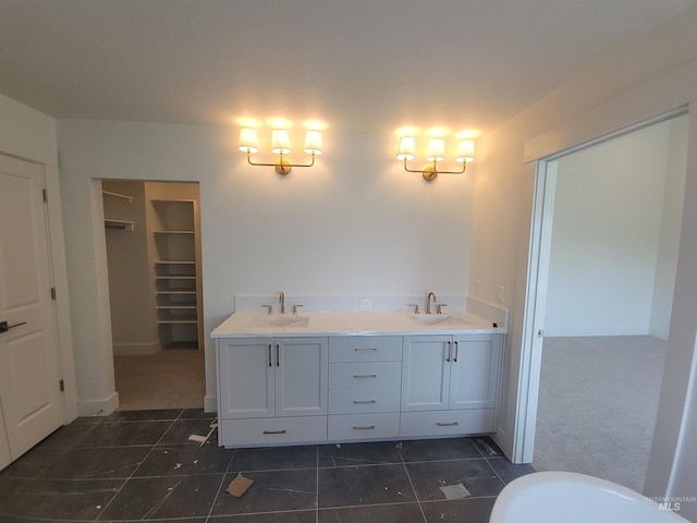 bathroom with a spacious closet, tile patterned flooring, double vanity, and a sink