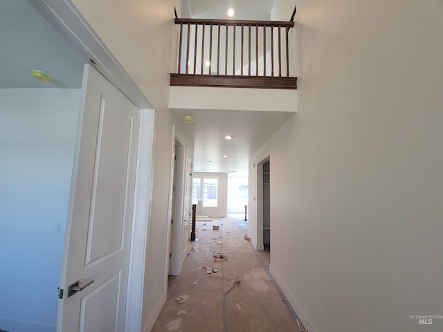 hallway featuring concrete flooring and baseboards
