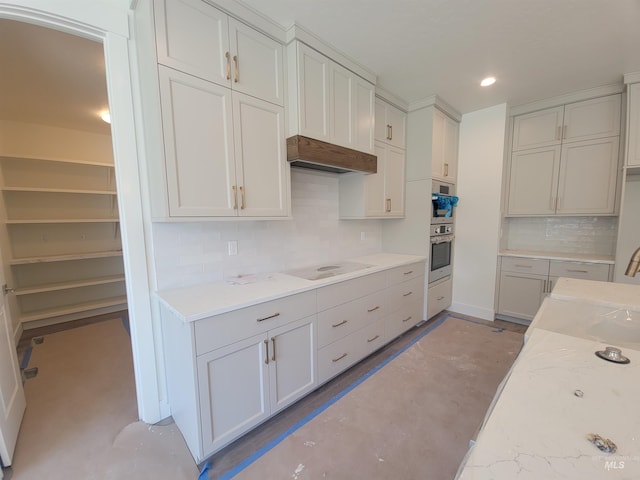 kitchen featuring decorative backsplash, electric cooktop, recessed lighting, concrete flooring, and range hood