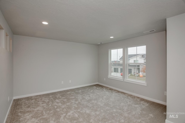 spare room featuring baseboards, visible vents, and light colored carpet