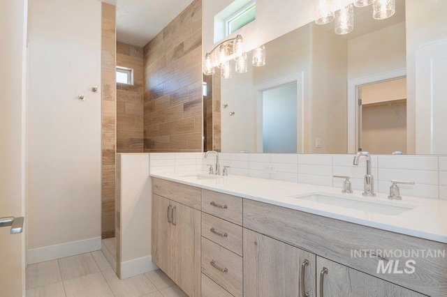 bathroom with tile patterned flooring, vanity, and a tile shower