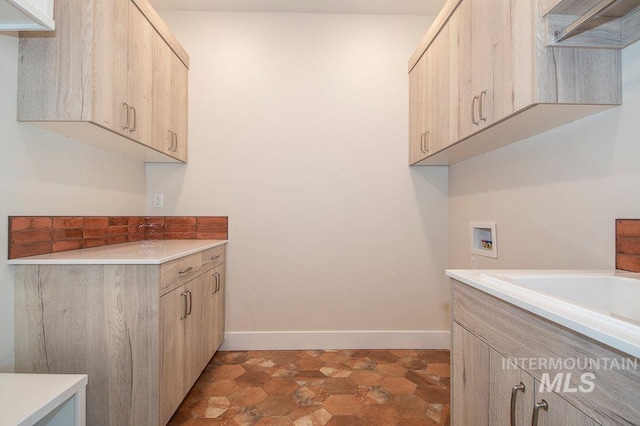 clothes washing area featuring washer hookup and cabinets