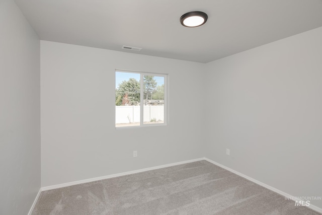 carpeted spare room with baseboards and visible vents