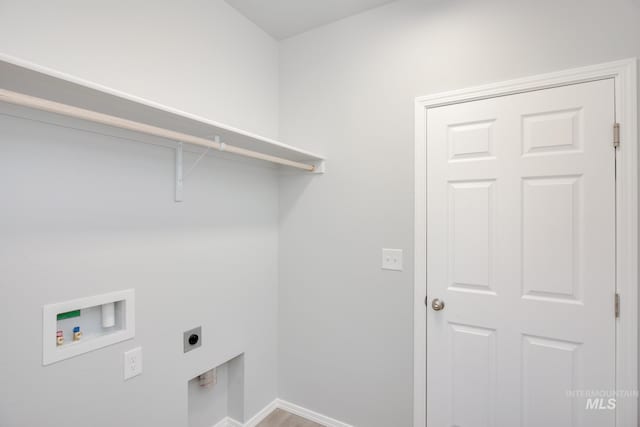 laundry room featuring baseboards, hookup for a washing machine, wood finished floors, laundry area, and electric dryer hookup