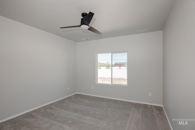 empty room featuring carpet floors, a ceiling fan, baseboards, and visible vents
