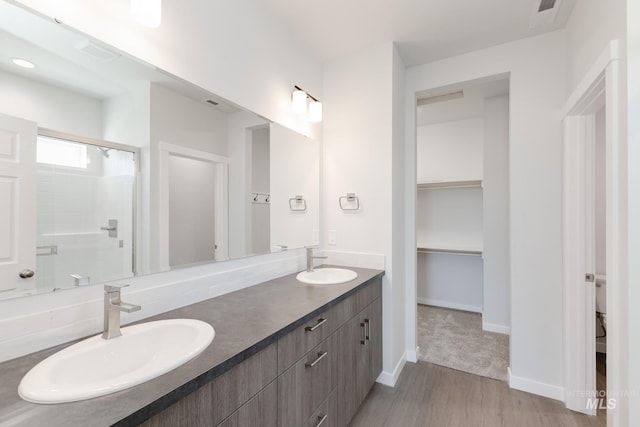 8349 S Sansa Ave, Kuna, ID 83634 - full bath with a stall shower, a walk in closet, wood finished floors, double vanity, and toilet
