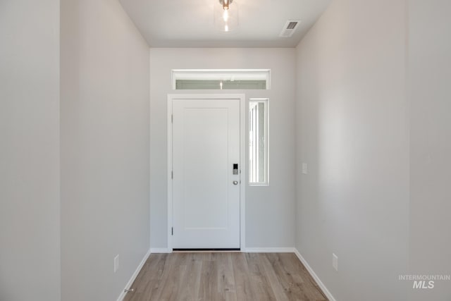 foyer entrance featuring baseboards, visible vents, and light wood-style floors