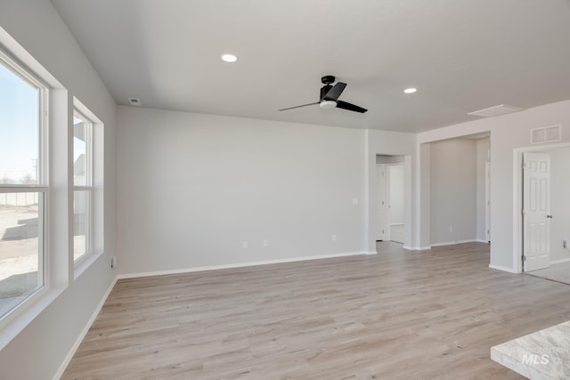 spare room with ceiling fan, light wood-style flooring, baseboards, and visible vents