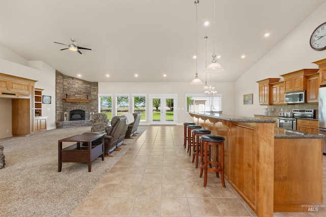 2790 S Mcdermott Rd, Nampa, ID 83687 - kitchen with appliances with stainless steel finishes, a ceiling fan, a fireplace, a kitchen bar, and recessed lighting