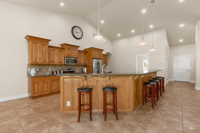 2790 S Mcdermott Rd, Nampa, ID 83687 - kitchen featuring stainless steel appliances, brown cabinets, a breakfast bar area, tasteful backsplash, and light tile patterned floors