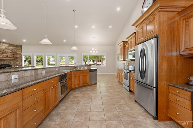 2790 S Mcdermott Rd, Nampa, ID 83687 - kitchen with stainless steel appliances, lofted ceiling, tasteful backsplash, brown cabinets, and a chandelier