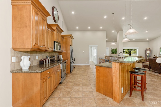 2790 S Mcdermott Rd, Nampa, ID 83687 - kitchen featuring appliances with stainless steel finishes, a breakfast bar, light tile patterned floors, tasteful backsplash, and dark stone counters