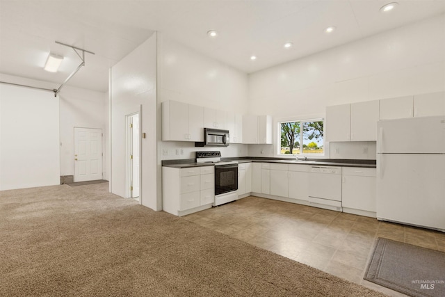 2790 S Mcdermott Rd, Nampa, ID 83687 - kitchen featuring white appliances, dark countertops, a towering ceiling, a sink, and recessed lighting