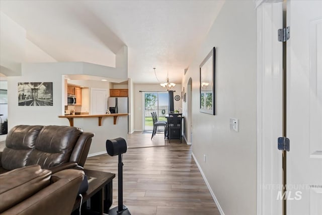 3918 Fallwood Cir, Caldwell, ID 83607 - living area featuring a chandelier, wood finished floors, and baseboards