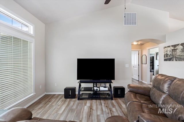 3918 Fallwood Cir, Caldwell, ID 83607 - living room with arched walkways, light wood-style floors, vaulted ceiling, ceiling fan, and baseboards