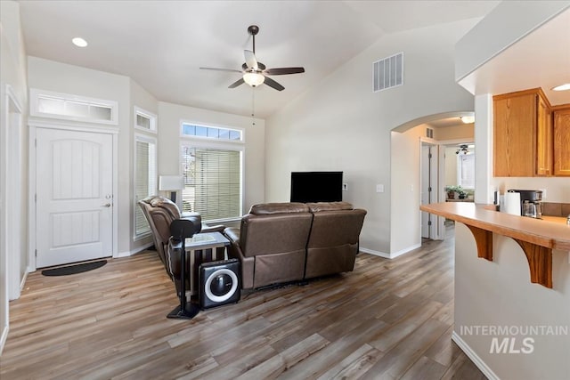 3918 Fallwood Cir, Caldwell, ID 83607 - living area featuring ceiling fan, arched walkways, light wood-type flooring, baseboards, and high vaulted ceiling