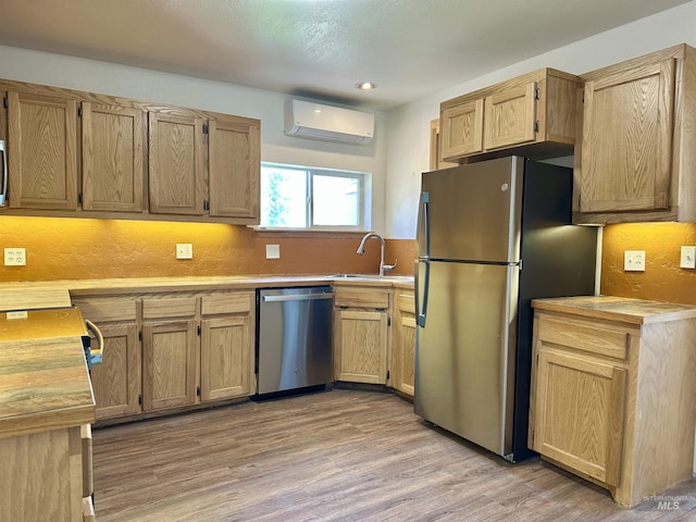 408 Walnut St, Nezperce, ID 83543 - kitchen with a sink, light countertops, light wood-style flooring, stainless steel appliances, and a wall unit AC
