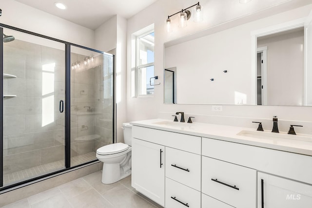 bathroom featuring double vanity, a stall shower, toilet, and a sink