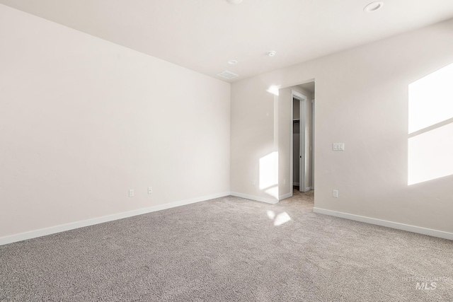 carpeted empty room with visible vents and baseboards