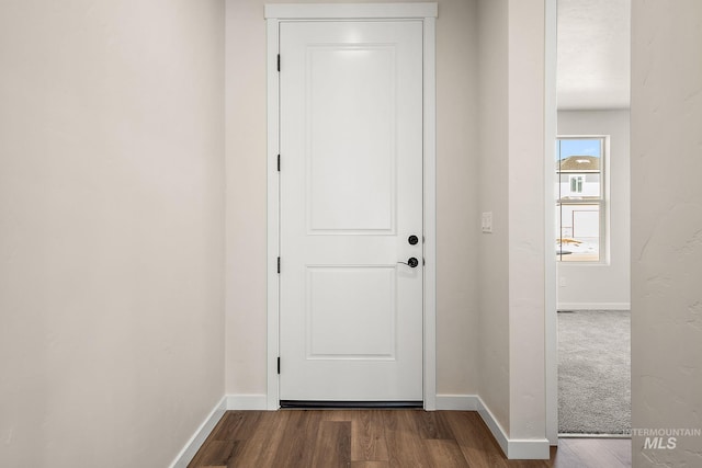 doorway to outside with baseboards and wood finished floors