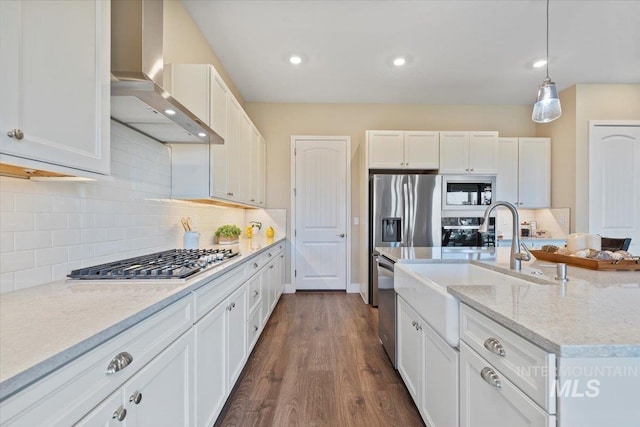 kitchen with white cabinetry, stainless steel appliances, dark wood-type flooring, and wall chimney range hood