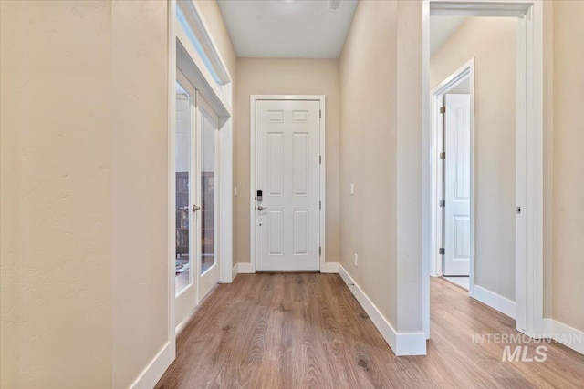 corridor featuring baseboards and wood finished floors