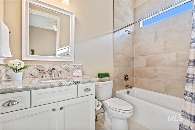 full bathroom featuring toilet, vanity, shower / tub combo, and a ceiling fan