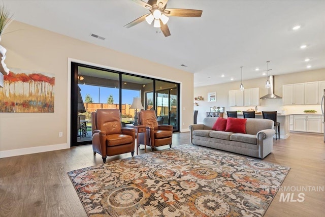 living area featuring recessed lighting, visible vents, baseboards, and light wood finished floors