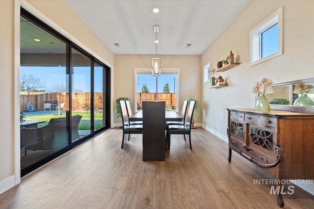 dining area with visible vents, baseboards, and wood finished floors