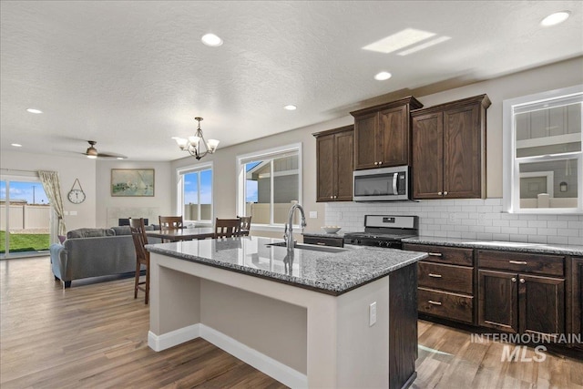 11638 W Quintale Dr, Nampa, ID 83686 - kitchen featuring stainless steel appliances, light wood finished floors, a sink, a chandelier, and recessed lighting