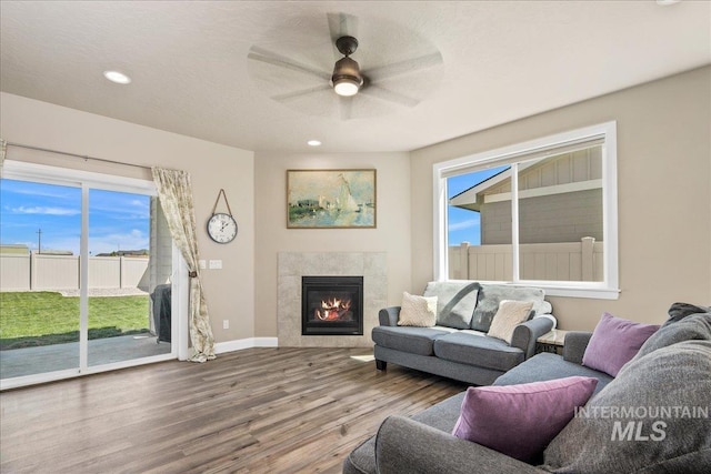 11638 W Quintale Dr, Nampa, ID 83686 - living area featuring a tiled fireplace, wood finished floors, a ceiling fan, recessed lighting, and baseboards