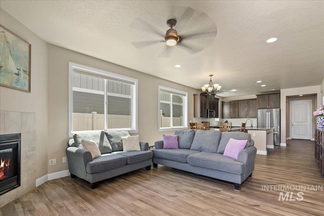 11638 W Quintale Dr, Nampa, ID 83686 - living room featuring a chandelier, wood finished floors, ceiling fan, baseboards, and recessed lighting