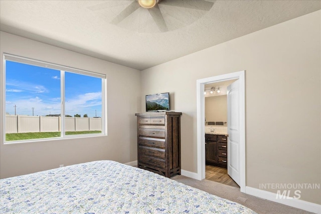 11638 W Quintale Dr, Nampa, ID 83686 - bedroom with light carpet, baseboards, ensuite bath, a textured ceiling, and ceiling fan