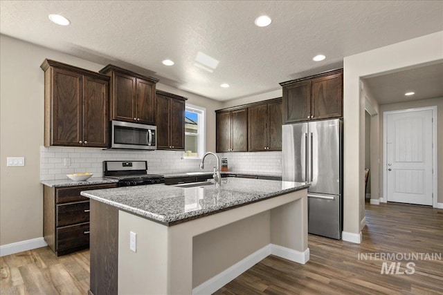 11638 W Quintale Dr, Nampa, ID 83686 - kitchen featuring stainless steel appliances, a sink, dark brown cabinets, decorative backsplash, and recessed lighting