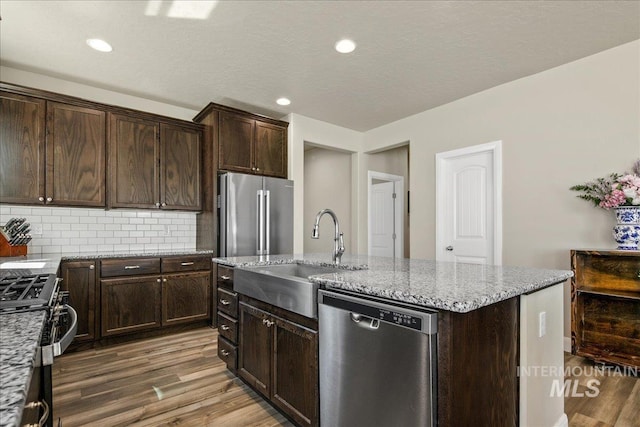 11638 W Quintale Dr, Nampa, ID 83686 - kitchen featuring appliances with stainless steel finishes, a sink, wood finished floors, light stone counters, and recessed lighting