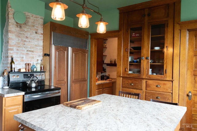 2771 S 850 E, Hagerman, ID 83332 - kitchen featuring stainless steel electric range oven, paneled fridge, brown cabinets, and light countertops