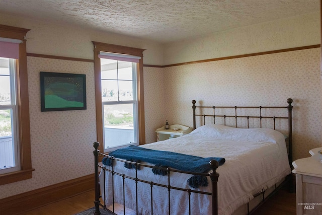 2771 S 850 E, Hagerman, ID 83332 - bedroom with wood finished floors, baseboards, wallpapered walls, and a textured ceiling